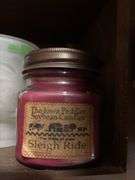 Cupboard full of partially burned candles and holiday decor