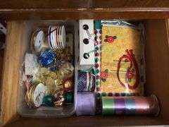 Contents of dresser include holiday decor, wrapping paper, tissue paper, ribbon and bags