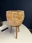 Basket style planter on wooden legs, handmade in Vietnam Approx 22” tall