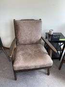 Two padded arm chairs with throw pillows, small side table and decor