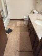 Contents of two baths includes cleaning supplies, bandaids, scales, rugs, etc