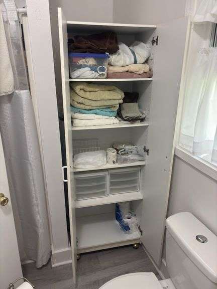 Double door, rolling white storage cupboard with bath towels and storage containers, hamper, scale image