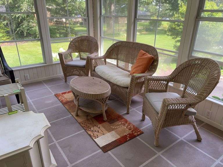 Tan painted wicker patio set includes settee, table and two chairs and fall colored runner rug image
