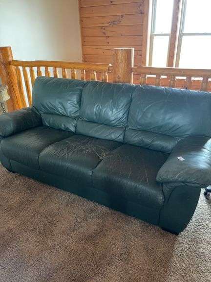 Green leather sofa, has lots of scratches image