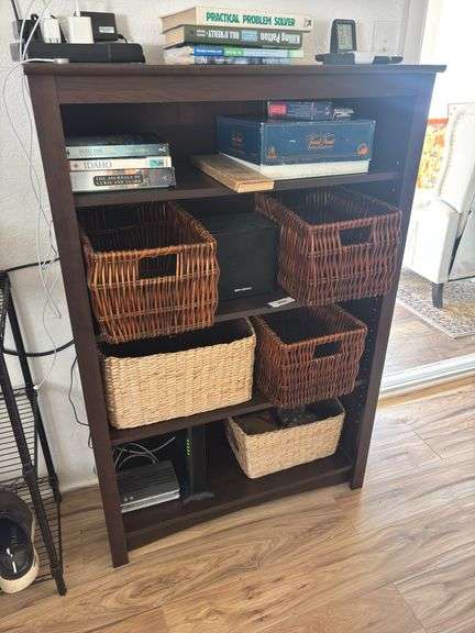Wooden bookshelf and storage baskets with games and books image