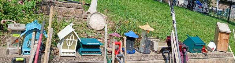 Assortment of bird feeders and houses on retaining wall image