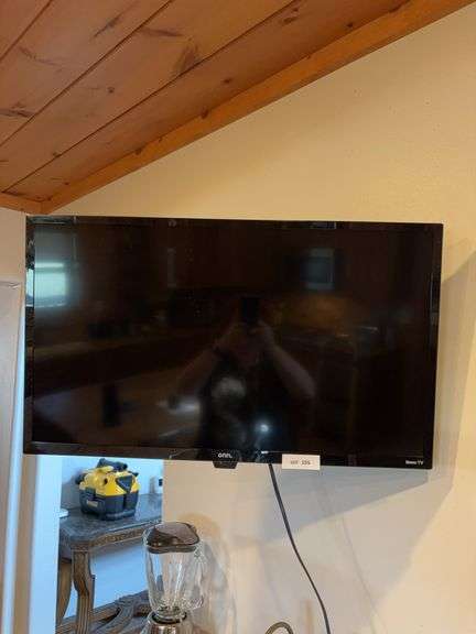 ONN  32” Roku TV with remote, being tools to remove wall bracket image