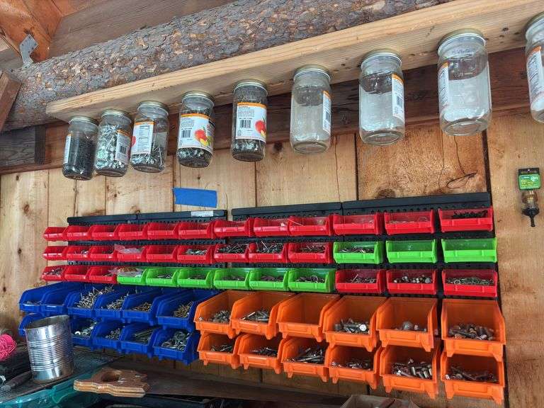 Multiple colored nuts and bolts bins full of hardware bring tools to remove from the wall image