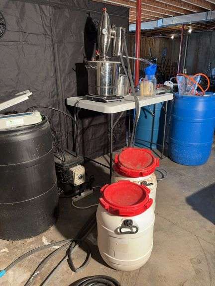 Alcohol Distillery, table with sink, scale, blue barrels, white containers, black barrel, all tubing-buyer will have to disassemble to remove image