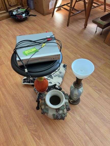 Catch all group includes table, vase, lamp, blanket and DVD player image