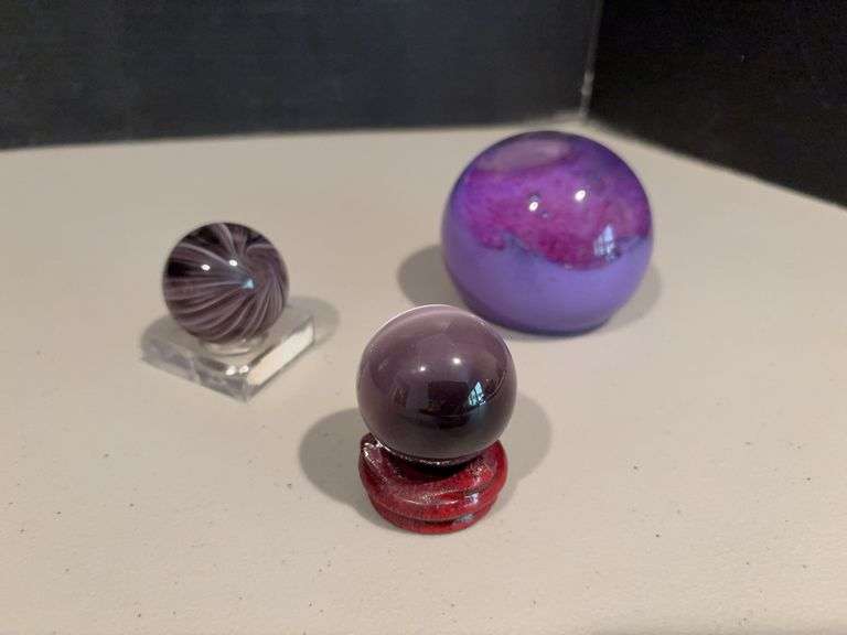 Two “marbles” w stands and purple glass paperweight image