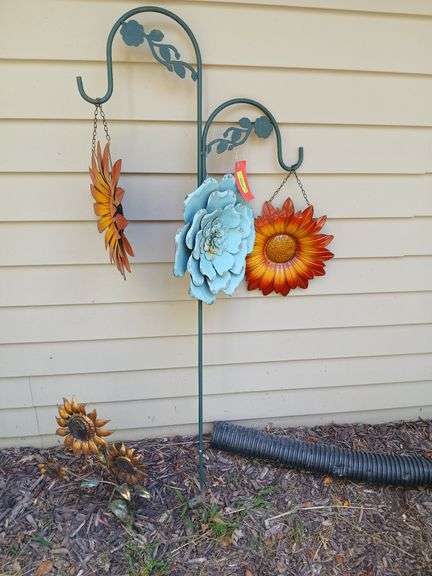 Shepherds hook w metal hanging flowers and a ground sunflower image