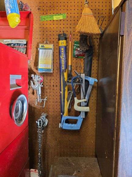 Items on pegboard include nail belt, chain hooks, saws, rope, window squeegee, face shield, C clamps image