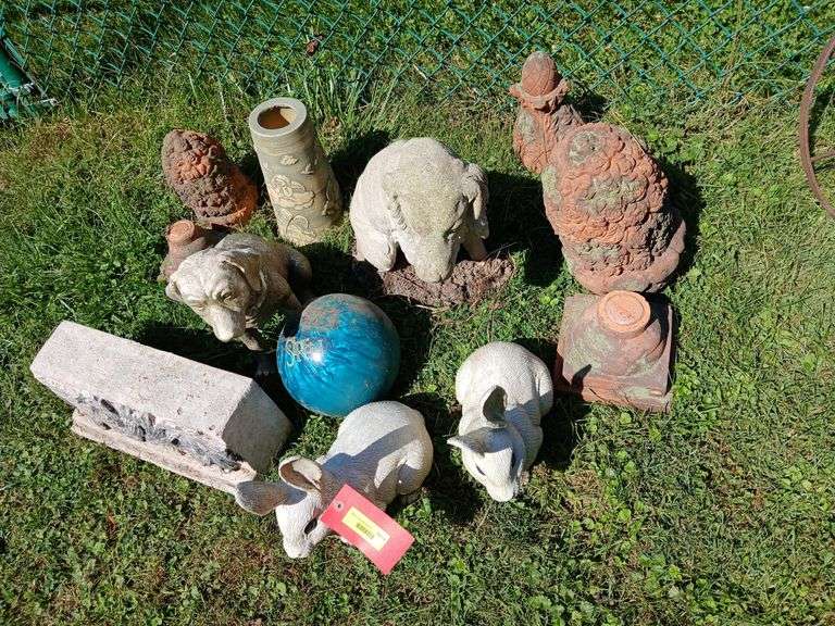 Yard art in varying condition includes cement dog and a pretty blue bowling ball image