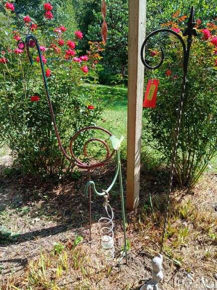Two shepherds hooks, hanging squirrel bird feeder and a flamingo image