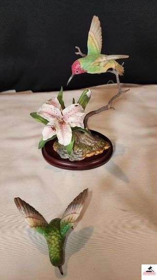 (2) MARURI HUMMINGBIRD FINE  PORCELAIN AND BRONZE STUDIO DESIGN H8905 ANNA'S HUMMINGBIRD WITH LILY, CIRCA 1989, BROKEN LIMB AND A RUBY THROATED HUMMINGBIRD WITH ORCHAD, LEAF MISSING OR BIRD, WING BROKEN - (2) HUMMINGBIRDS - (GREAT ROOM)