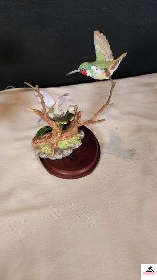 (2) MARURI HUMMINGBIRD FINE  PORCELAIN AND BRONZE STUDIO DESIGN H8905 ANNA'S HUMMINGBIRD WITH LILY, CIRCA 1989, BROKEN LIMB AND A RUBY THROATED HUMMINGBIRD WITH ORCHAD, LEAF MISSING OR BIRD, WING BROKEN - (2) HUMMINGBIRDS - (GREAT ROOM)