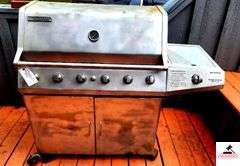 BRINKMANN GAS GRILL - TOP IS 17 1/2" DEEP X 35 1/2" WIDE - SIDE BURNER - APPEARS BEEN PAINTED - ROLLING FEET MISSING / BENT - PROPANE TANK INCLUDED - COVER - (PATIO)
