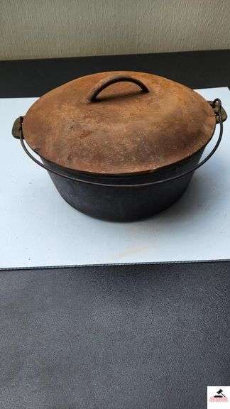 DUTCH OVEN WITH LID AND METAL VAIL - NEEDS CLEANING LID IS RUSTY - (TRAILER)