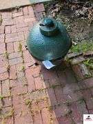 BIG GREEN EGG BARBEQUE GRILL - SMALL SIZE - GREEN COLOR - TOP COVER CRACKED HAS CHIP MISSING - (BESIDE GARAGE)