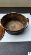 DUTCH OVEN WITH LID AND METAL VAIL - NEEDS CLEANING LID IS RUSTY - (TRAILER)