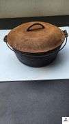 DUTCH OVEN WITH LID AND METAL VAIL - NEEDS CLEANING LID IS RUSTY - (TRAILER)
