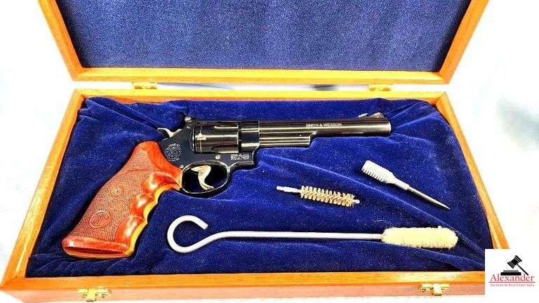 SMITH & WESSON 29-10 BLUE REVOLVER - .44 MAG - WOOD DISPLAY BOX - DELUXE CHECKERED GRIPS WITH THUMB GRIP - 6 1/2" BARREL - DEEP BLUING COLOR - MINOR WEAR - ADJUSTABLE SIGHT - VERY LIGHT BLUE RUB AT END OF MUZZLE - WOOD CASE HAS A FEW LIGHT MARKS - HAS CLEANING ROD, SCREW DRIVER, AND WIRE BRUSH - EXCELLENT TO MINT CONDITION - S/N DRB5275 image