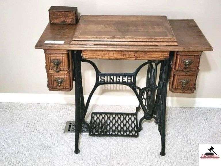 SINGER TREADLE SEWING MACHINE - WOOD CABINET - 4 DRAWERS WITH BRASS LION HEAD PULLS - END TRIM LOOSE - GOOD FINISH SOME VENEERING WORN AND RIPPLED - ATTACHMENT BOX - (MASTER BEDROOM) image