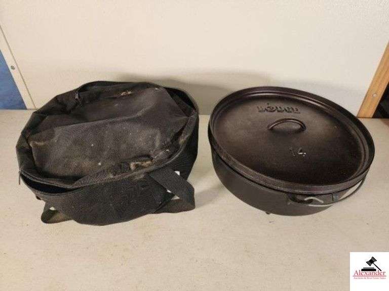 LODGE SEASONED DUTCH OVEN FOOTED - MARKED USA 14 CO - 14 INCH DIAMETER - 4 IN DEEP HAS LOOP HANDLE - COMES WITH CARRIER - (GARAGE) image
