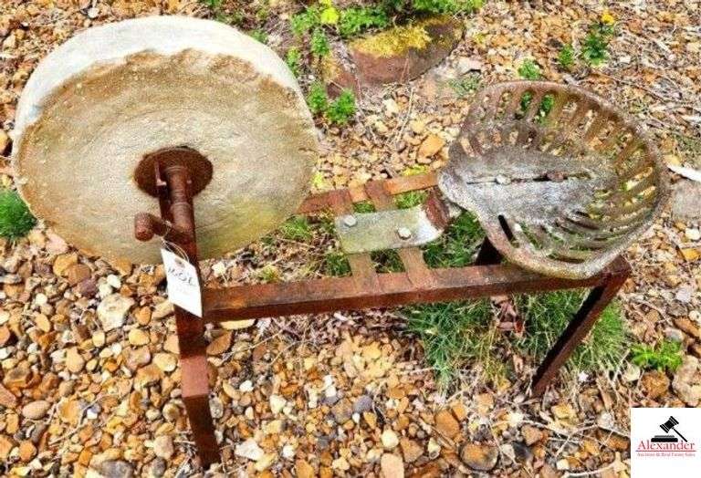 STONE GRINDING WHEEL WITH SHOP MADE STAND AND IRON IMPLEMENT SEAT - STONE WHEEL HAS CHIPE - (OUTSIDE) image