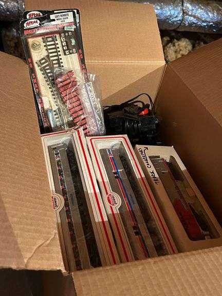 Box of train track, cars and other accessories image