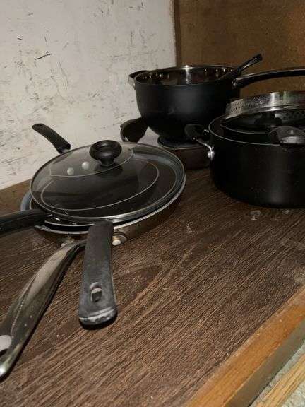 Contents of bottom kitchen cabinet below stove…..various pots and pans….most are non-stick Farberware…..also includes 2 PYREX pieces image