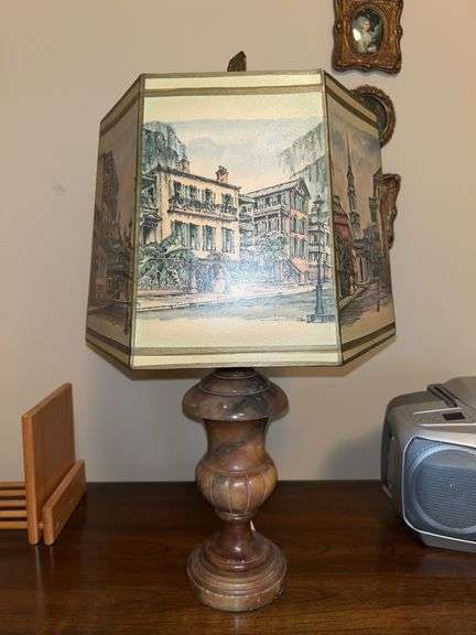 Table lamp with a multi-paneled shade featuring a watercolor-style illustration of a street scene with a marble-like base…..20” tall image