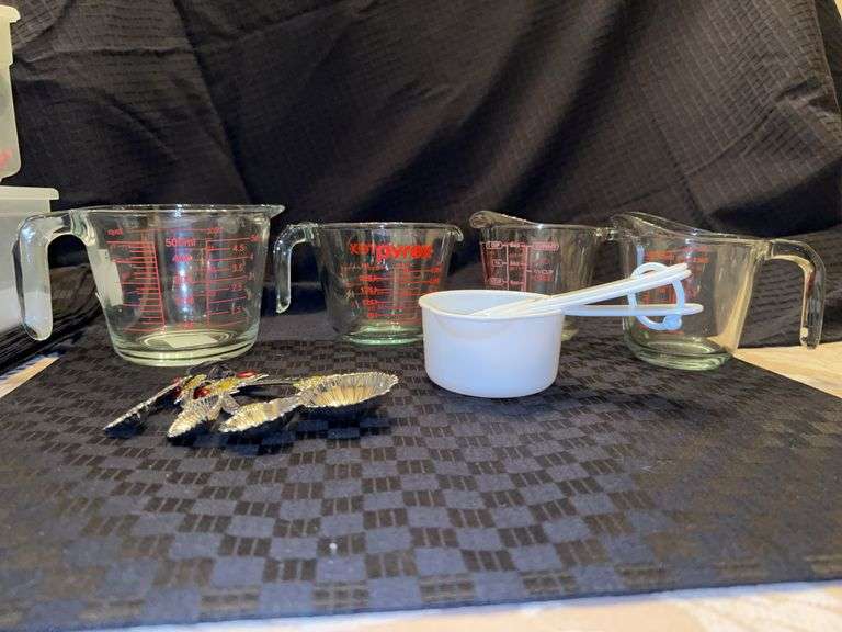 Assortment of glass measuring cups (1 PYREX, 1 Anchor Hocking and 2 unmarked), 3 white plastic and set of decorative metal measuring spoons image