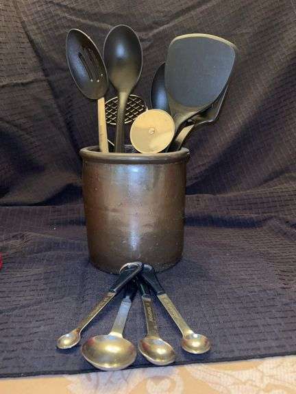 Vintage crock with kitchen utensils and measuring spoons image