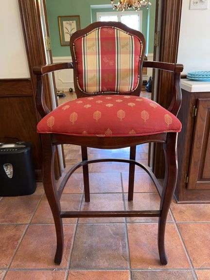 a Louis XV-style wooden bar stool with upholstered red and plaid/print fabric cushioned seat and back…..24 x 19 x 45-1/2 tall overall image