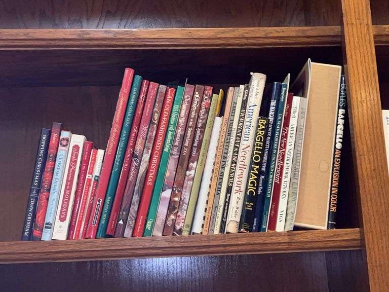Shelf of books regarding cross stitch, needlework, Southern Living Home Decor and more image