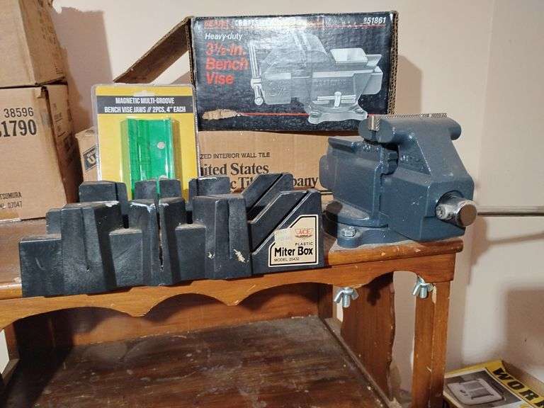 Craftsman Heavy Duty 3 1/2" Bench Vise attached to cabinet, Ace Plastic Miter Box attached to cabinet, 14" Mitre Back Saw, Portable Magnetic Multi-Groove Bench Vise Jaws 2 pc., 4" ea. and small two shelf wooden cabinet 30"T x 26"W x 17 1/2"D. Other contents not included image