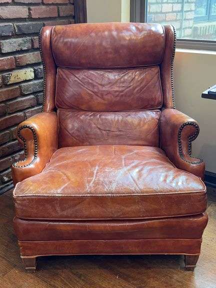 Rust color leather chair with brass studs….shows wear but would be a great display item for a consignment booth or storefront image
