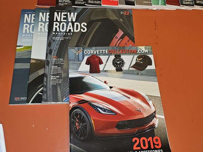 Grouping of Corvette dealership brochures, America sports car magazines, and new roads magazines.