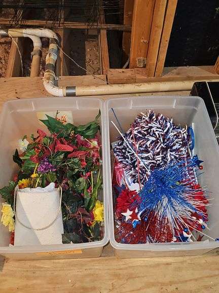 Two tubs. One containing artificial flowers, one containing 4th of July decorative items.