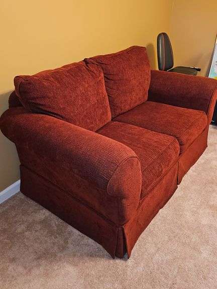 Ashley Furniture burgundy loveseat. 62X36x36 in tall. Seat height 18 in. Includes pillows and throws as shown in last photo.