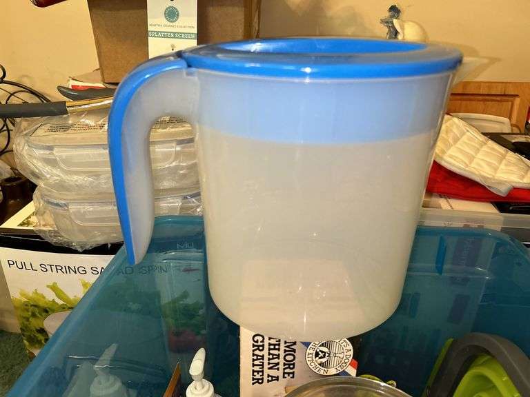 Tote full of miscellaneous household/kitchen items…..2 teal pitchers (acrylic and heavy plastic, collapsible strainer, splatter screen and more