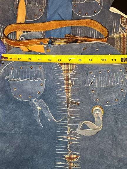 Little cowpoke leather chaps and vest in blue, natural leather color chaps, and pants with fringe and Teepee look on front, cowboy hat and drum.