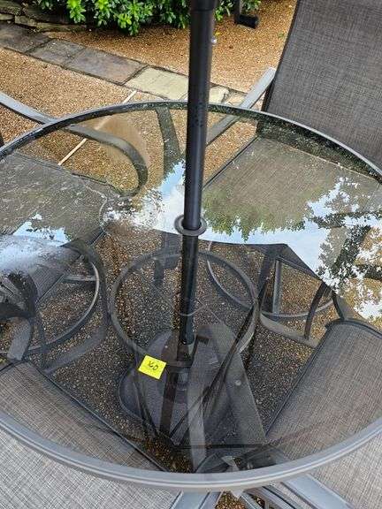 Glass top table, four swivel chairs, and umbrella.