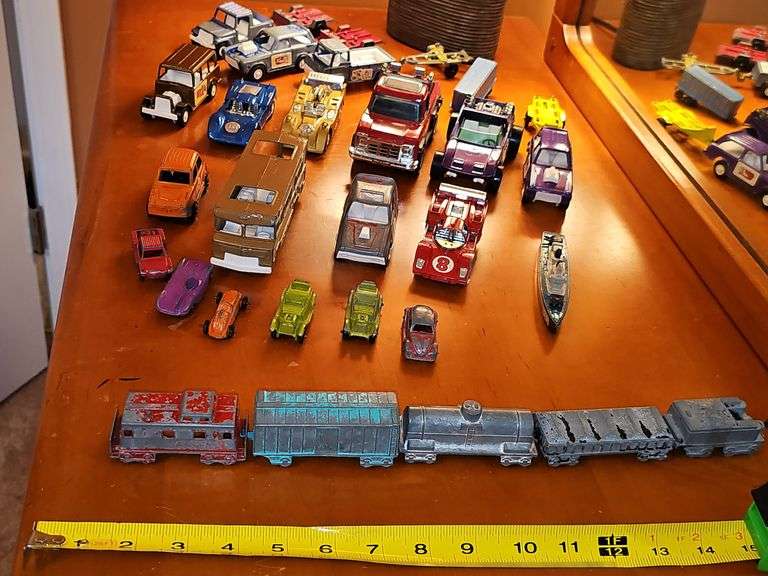 Diecast vehicles. All have been played with. The train in the front is Midge Toy, most of the rest are Tootsie Toy.