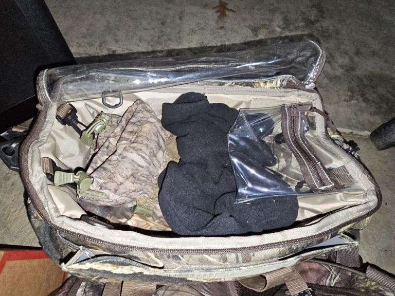 Two camo duffel bags. The smaller one has winter gloves in it.