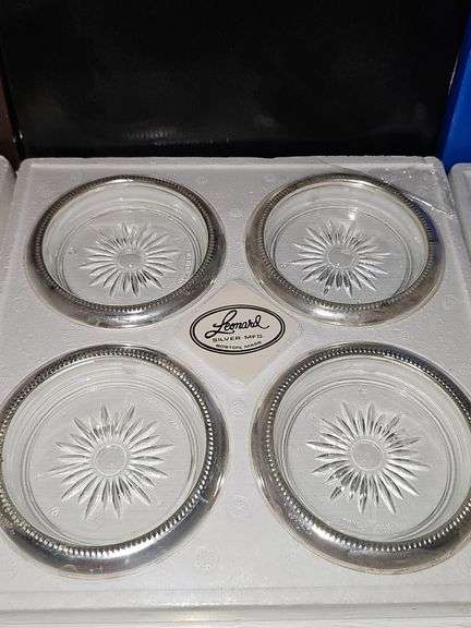Three boxes of silver plate rimmed coasters or ashtrays. One box has not been opened.