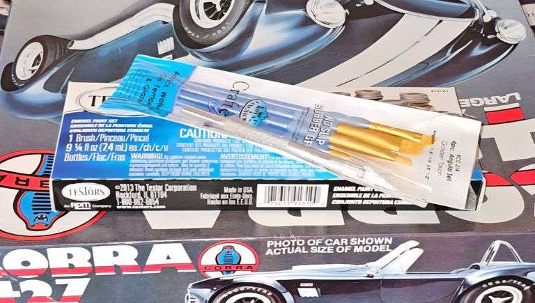 Unopened model airplane, model car, paint brushes and paints