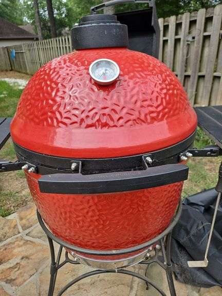 Red Kamado Joe Grill on rollaround iron stand w/cover and some like new accessories...